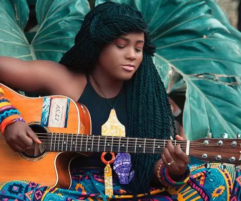 Young dominican girl playing guitar