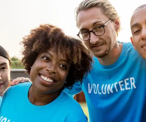 Group of people in “Volunteer” shirts taking a selfie