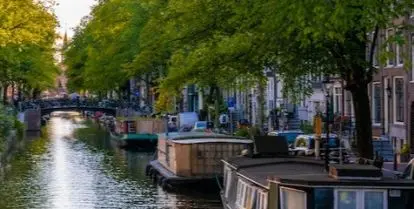 canal with boats, flowers, and trees
