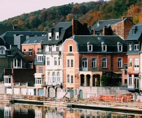 buildings in different colors sitting next to water