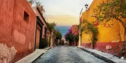 street lined with colorful buildings and trees with flowers