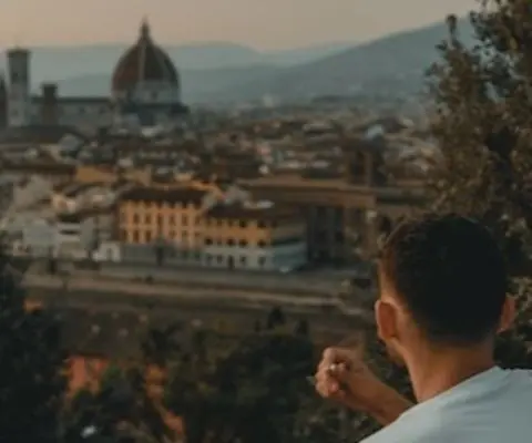 two people sitting near green trees overlooking Florence architecture in the background